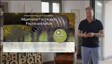 Mann präsentiert eine PowerPoint-Präsentation über allgemeine Fischkunde und Fischkrankheiten. Im Hintergrund ist ein Bild eines Fisches zu sehen, während der Fokus auf dem Vortragenden liegt.